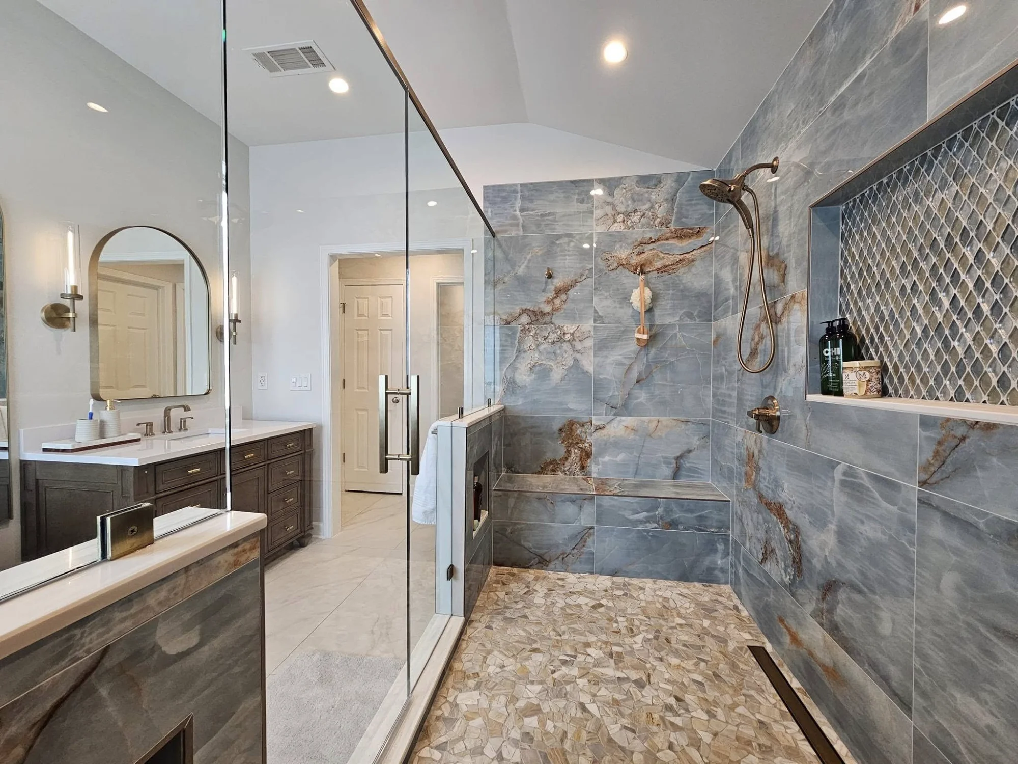 Luxury bathroom renovation by Arkham PMC featuring marble tile shower and custom vanity